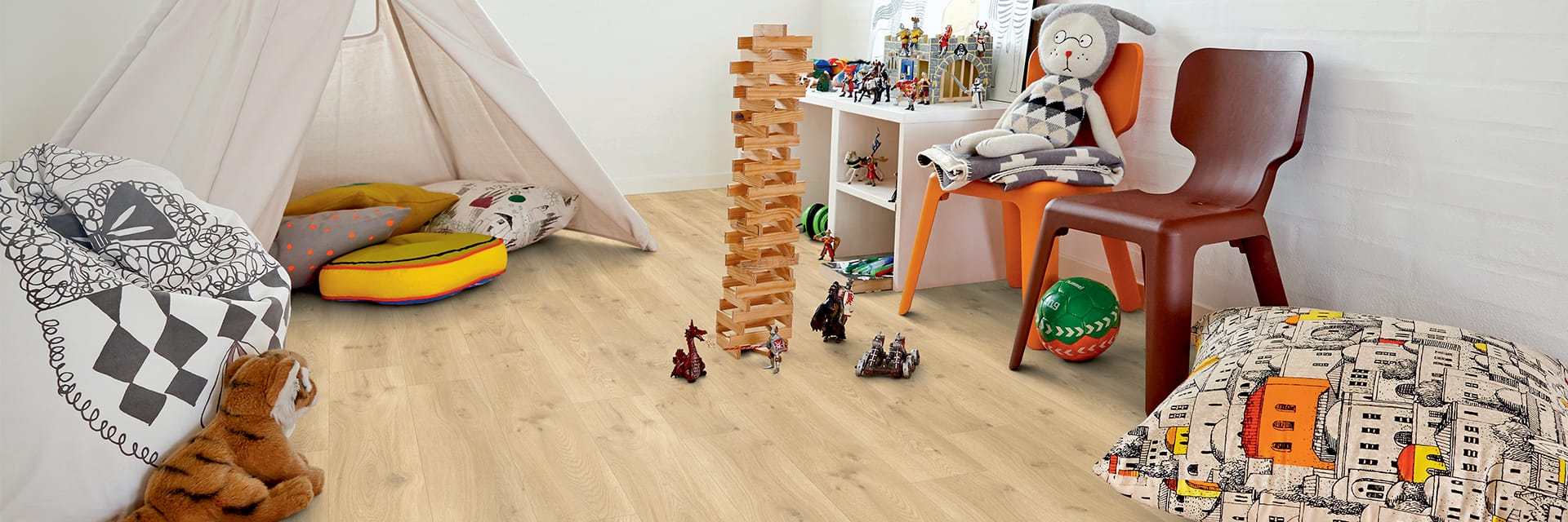 pokój dziecięcy z zabawkami leżącymi na beżowej podłodze winylowej